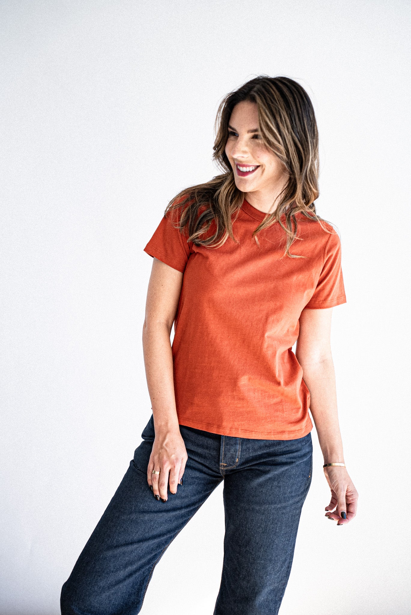 Model wearing the Reyes boxy tee in brick with dark wash denim jeans against a white backdrop.