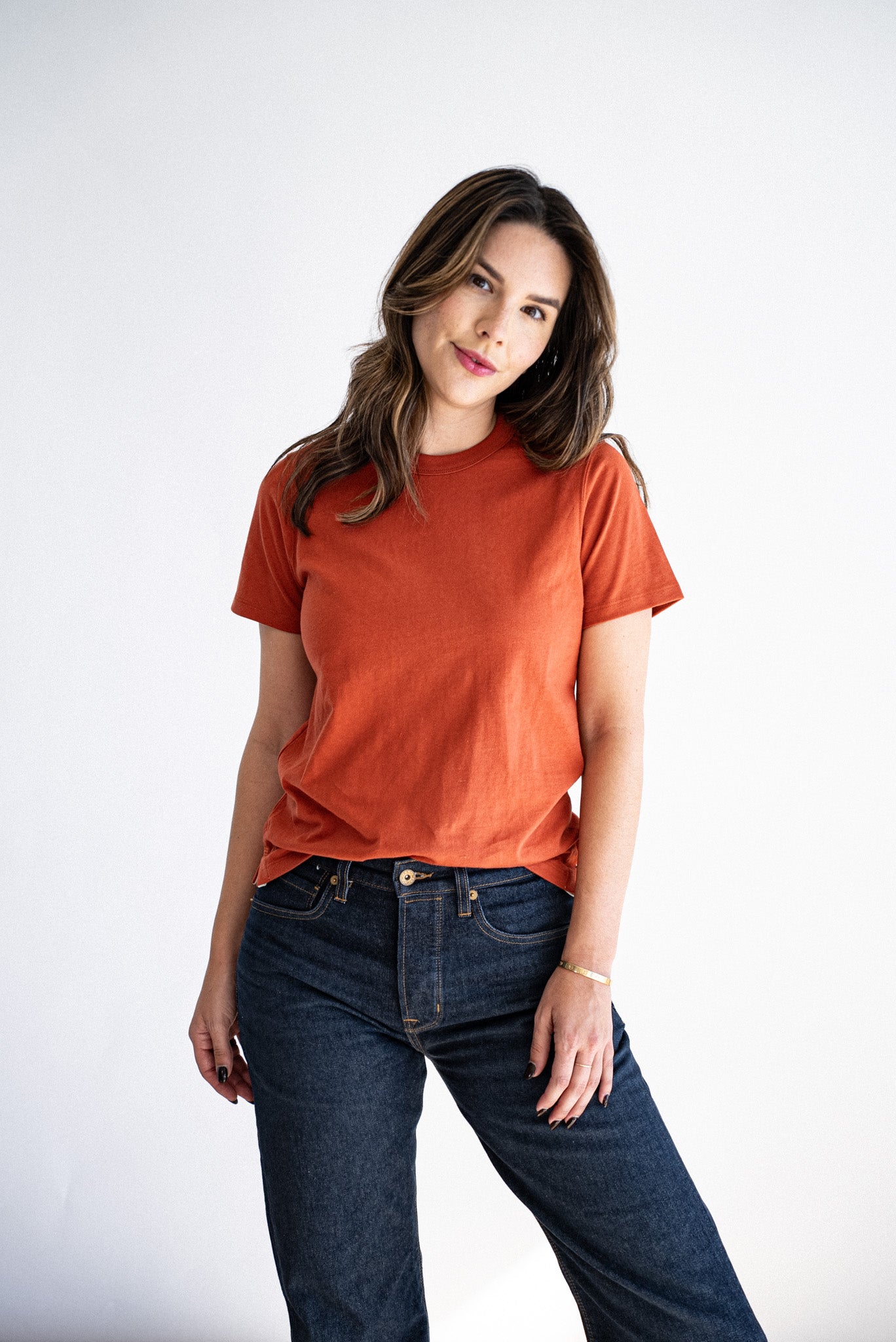 Model wearing the brick-colored Reyes boxy tee with dark selvedge denim jeans.