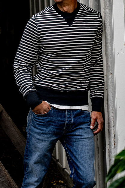 Navy and white striped Stinson rugby pullover worn on-model with blue jeans.