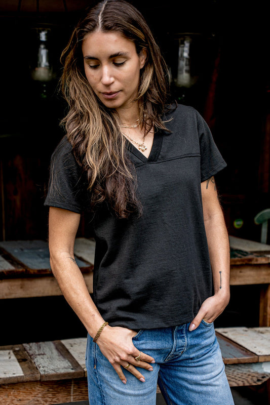 Basalt black Stinson V-neck jersey in heavyweight cotton, styled with blue jeans outdoors.