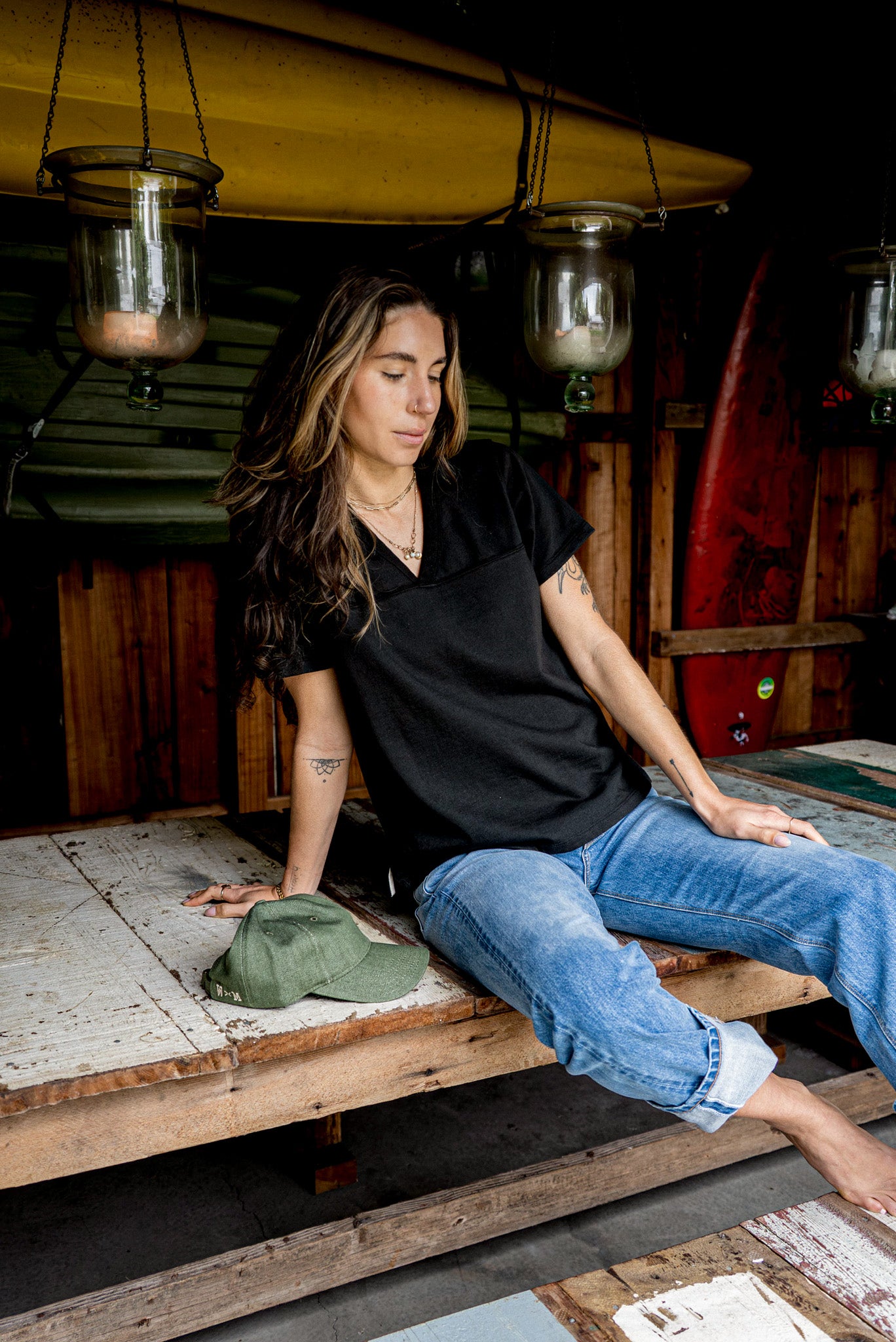 Basalt black Stinson V-neck cotton jersey worn with jeans on a rustic wooden bench.