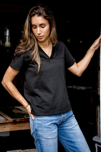 Woman wearing basalt black Stinson V-neck cotton jersey tee with light-wash jeans.