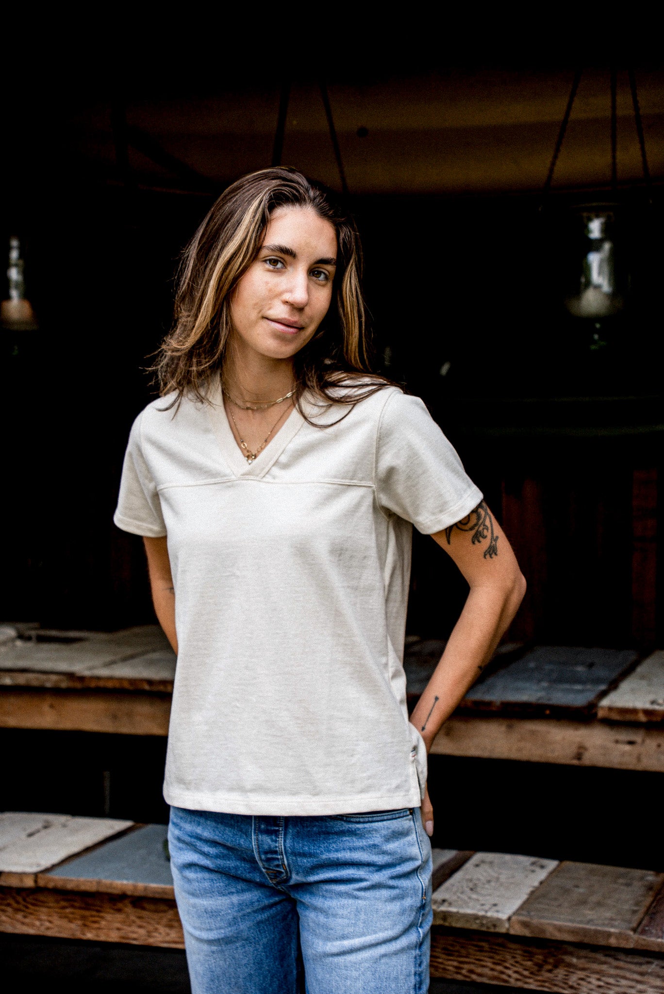 Person wearing natural cotton Stinson V-neck jersey tee with jeans, on-model front view.