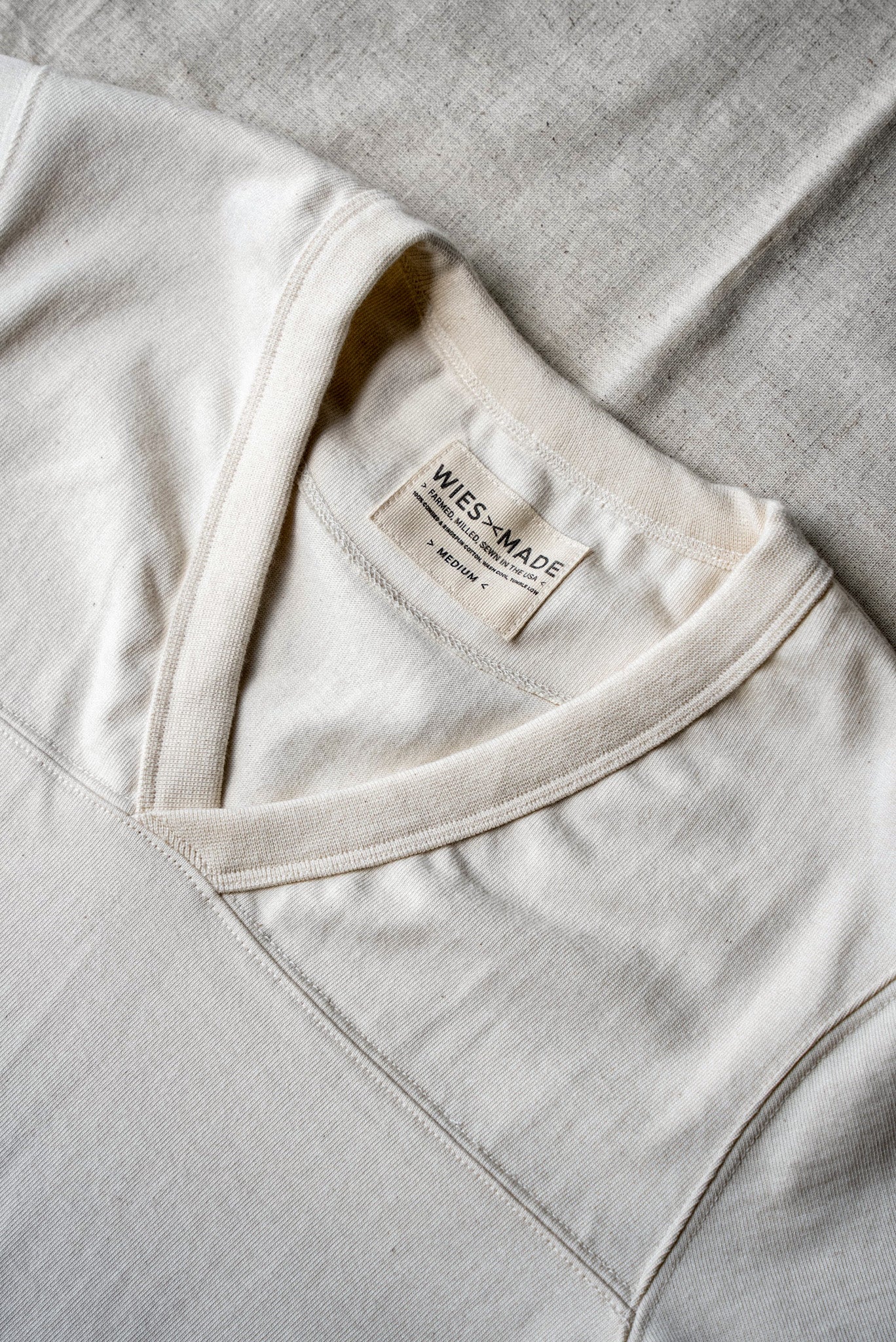 Close-up of natural cotton V-neck jersey collar with WiesMade label, made in USA.
