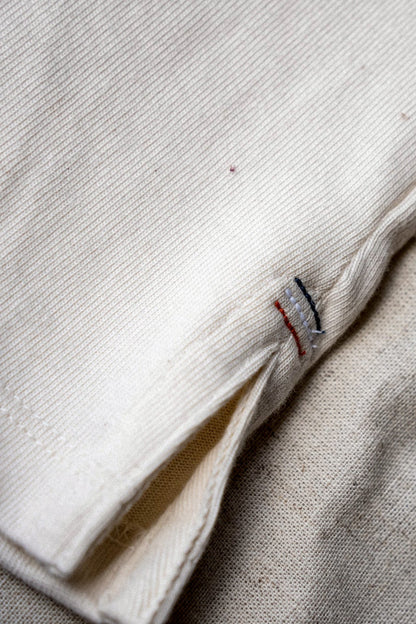 Natural 12oz cotton jersey hem with red, white, and blue triple bartack stitching and side vent.