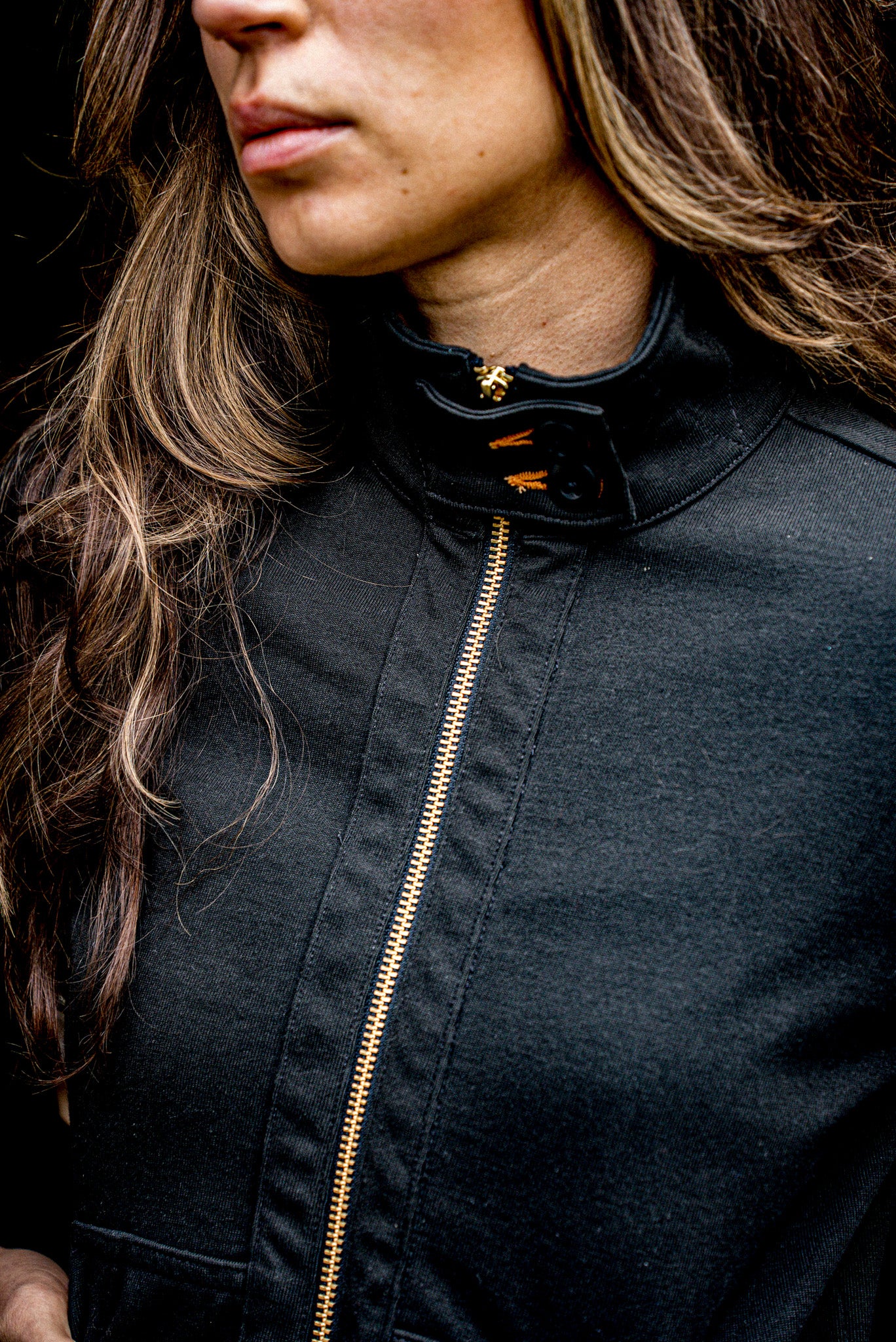 Detail of women's Stinson Moto cotton jacket in Basalt with brass zipper and stand collar.