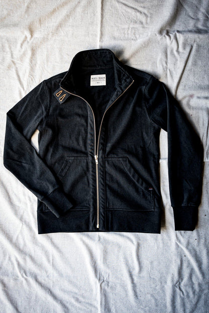 Women's basalt cotton moto jacket flat-lay showing brass zipper and stand collar.