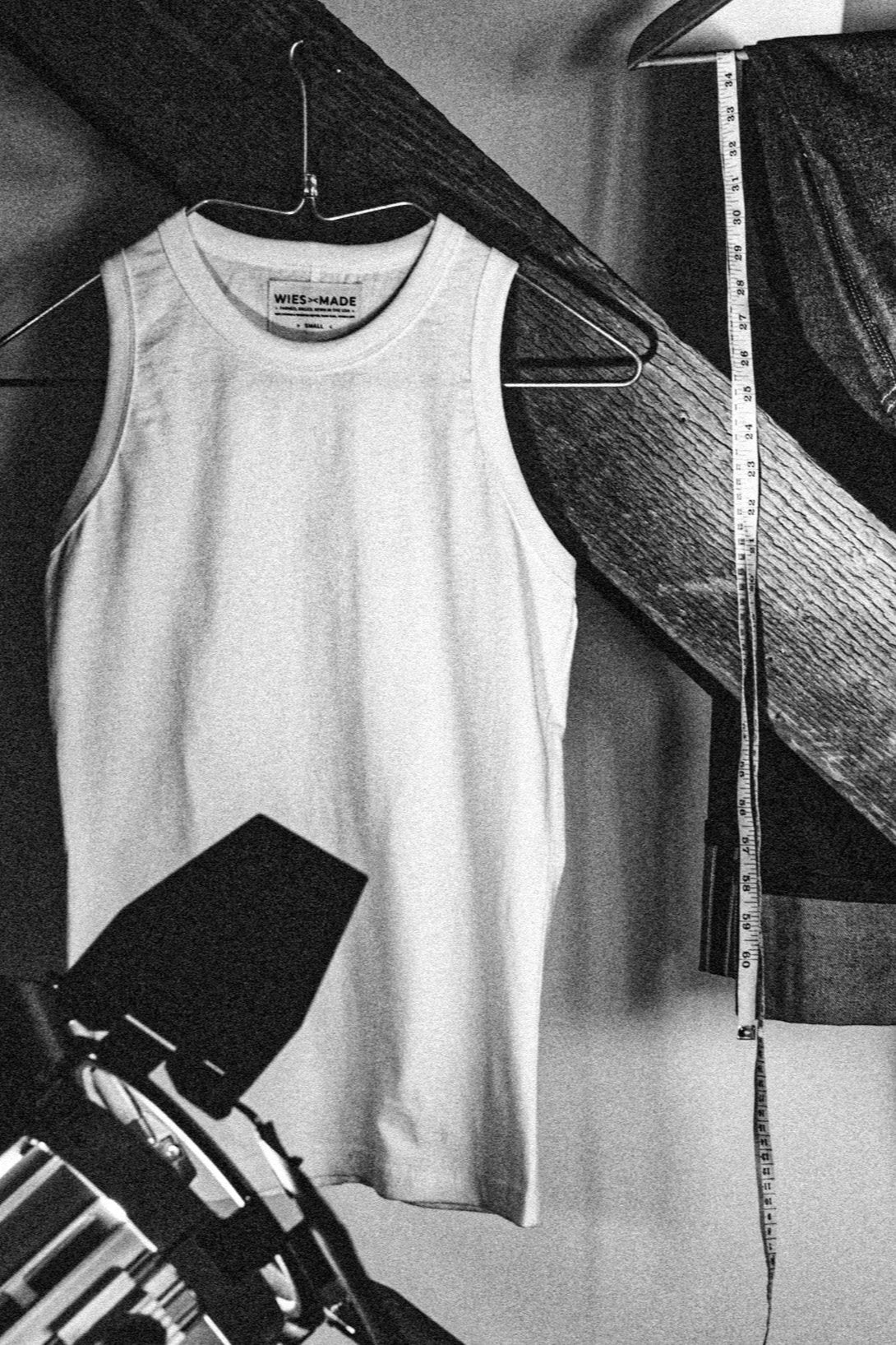 Natural cotton Bolinas tank top on a wire hanger beside a tape measure and sewing tools.