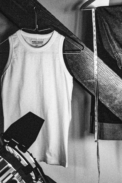 Reyes boxy cotton tank on a hanger in a workshop with denim and a tape measure.