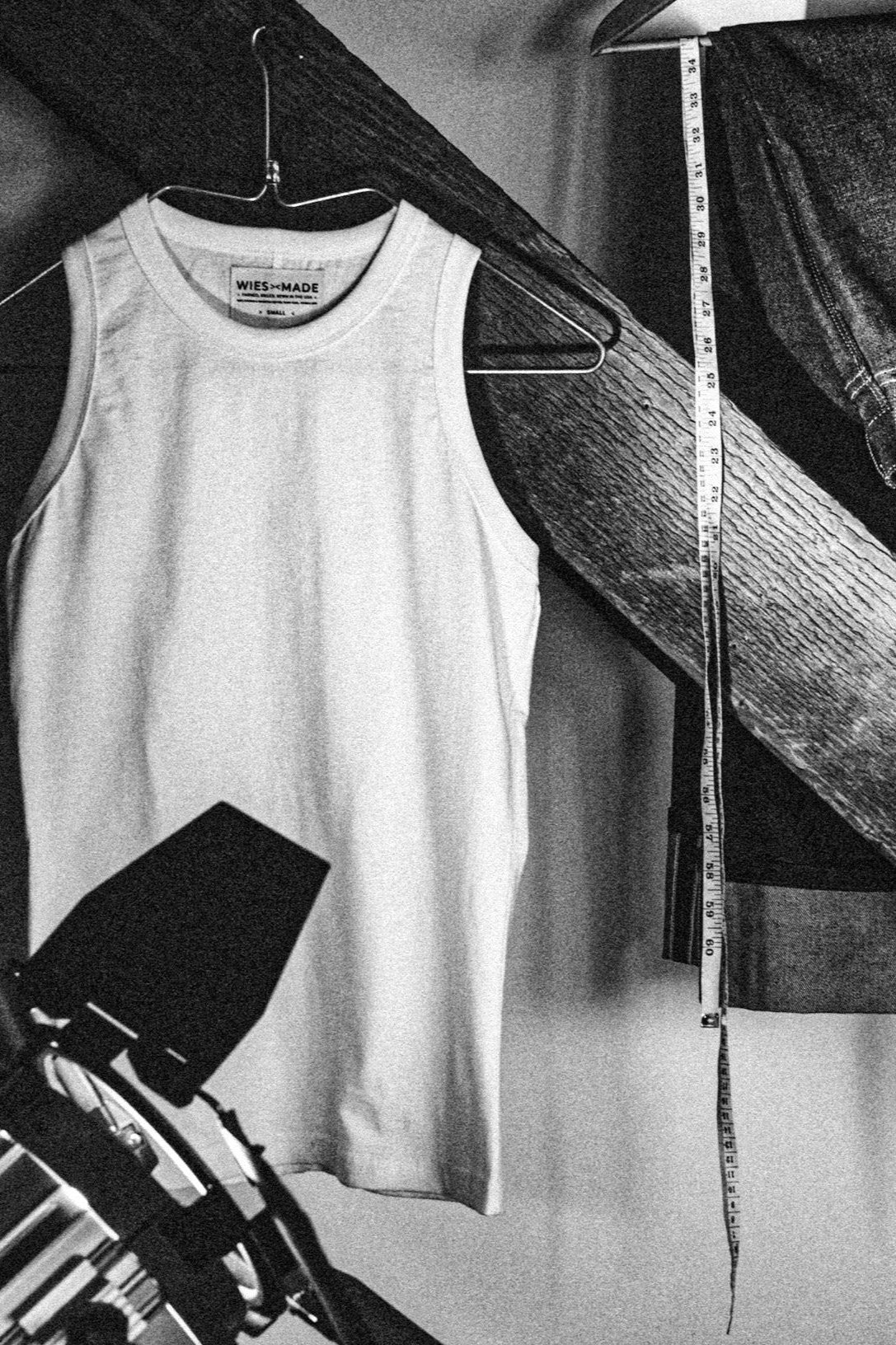 Bolinas cotton tank top on a hanger in a workshop with a tape measure and denim alongside.